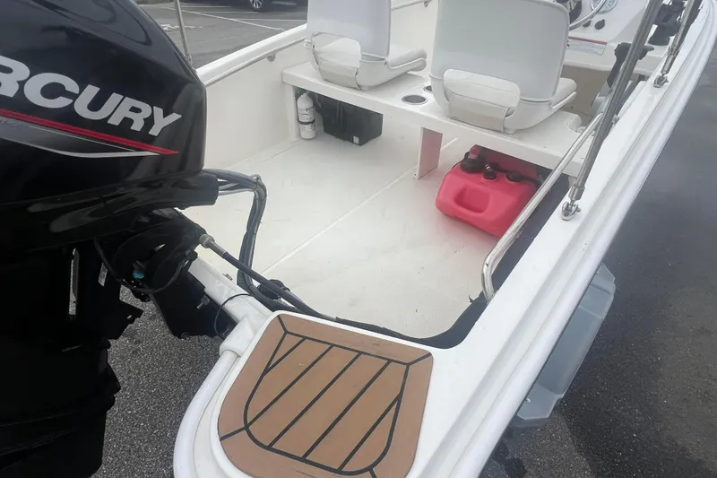 Slide: The Image of 2021 Boston Whaler 130 Super Sport boat interior with Mercury engine and seating. - 11