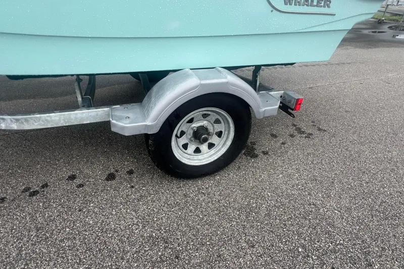 Slide: The Image of 2021 Boston Whaler 130 Super Sport on trailer, close-up of wheel and hull. - 6