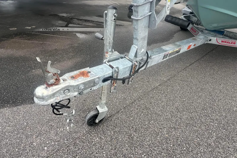 Slide: The Image of Trailer hitch of a 2021 Boston Whaler 130 Super Sport on wet pavement. - 7
