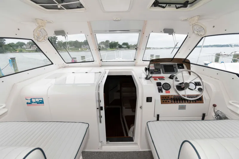 Slide: The Image of 2002 Mainship Pilot 34 Sedan interior with helm, steering wheel, and navigation equipment. - 10
