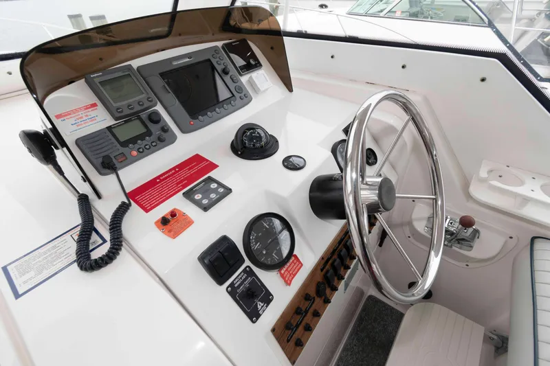 Slide: The Image of Cockpit of 2002 Mainship Pilot 34 Sedan with steering wheel and navigation instruments. - 12