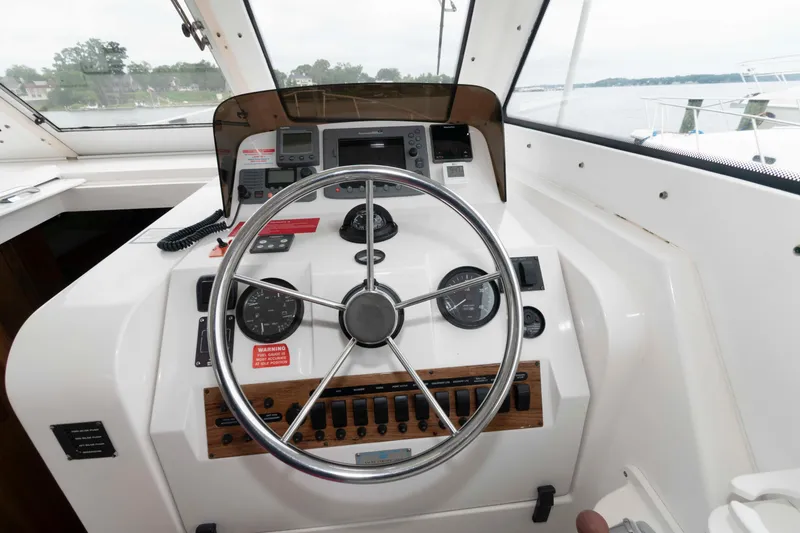 Slide: The Image of 2002 Mainship Pilot 34 Sedan helm with steering wheel and navigation controls. - 13