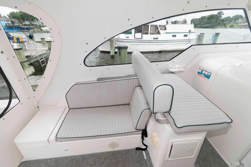 Slide: The Image of 2002 Mainship Pilot 34 Sedan interior with cushioned seating and waterfront view. - 15