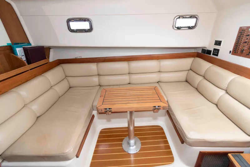 Slide: The Image of Interior of 2002 Mainship Pilot 34 Sedan with beige seating and wooden table. - 18