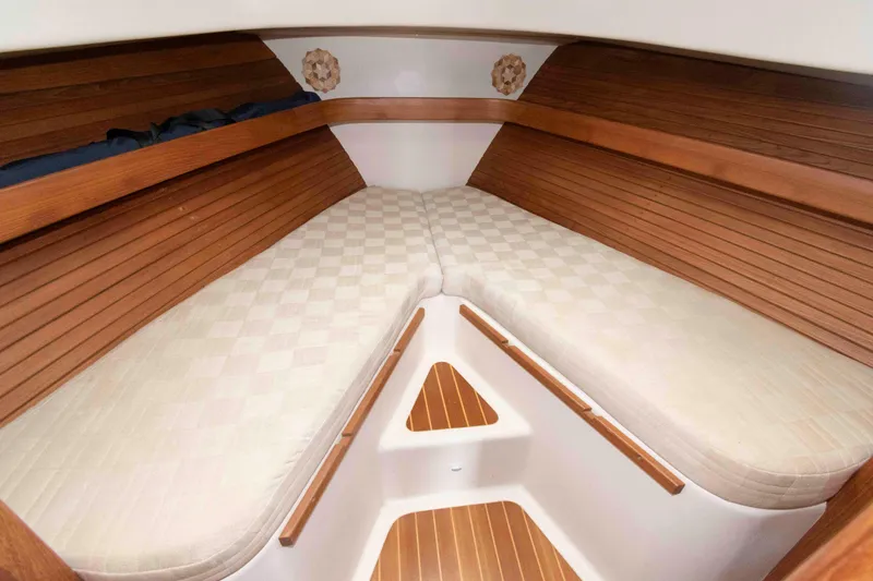 Slide: The Image of 2002 Mainship Pilot 34 Sedan cabin interior with wooden accents and cushioned seating. - 20