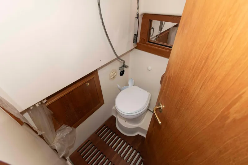 Slide: The Image of 2002 Mainship Pilot 34 Sedan bathroom with wooden accents and compact design. - 21