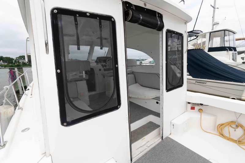 Slide: The Image of 2002 Mainship Pilot 34 Sedan boat interior with open door, docked at marina. - 8
