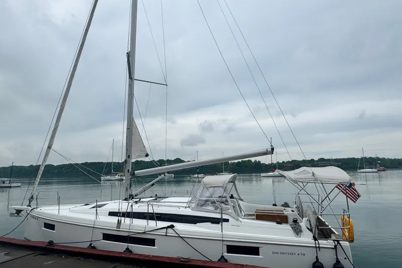 Slide: The Image of 2020 Jeanneau Sun Odyssey 410 sailboat docked on a calm lake. - 1
