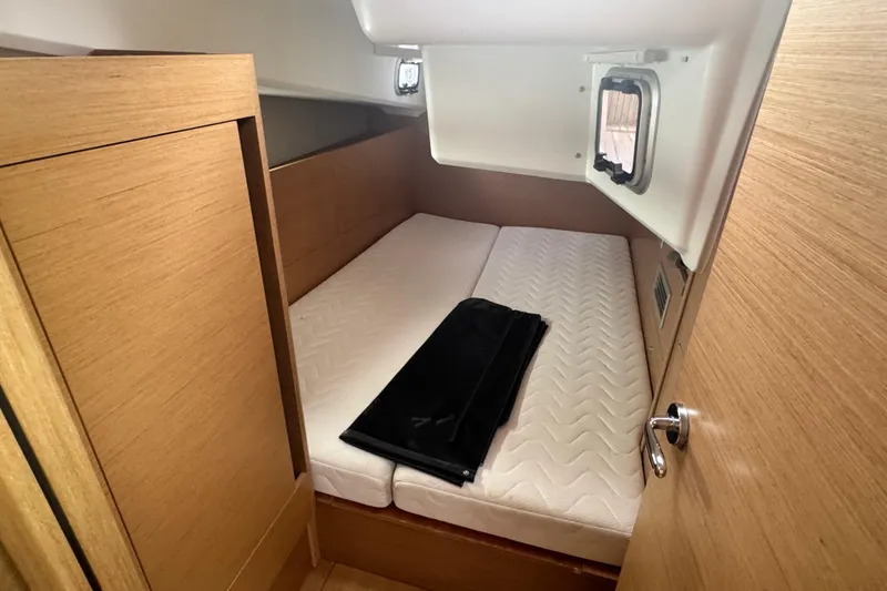 Slide: The Image of 2020 Jeanneau Sun Odyssey 410 cabin interior with wooden finish and mattress. - 13