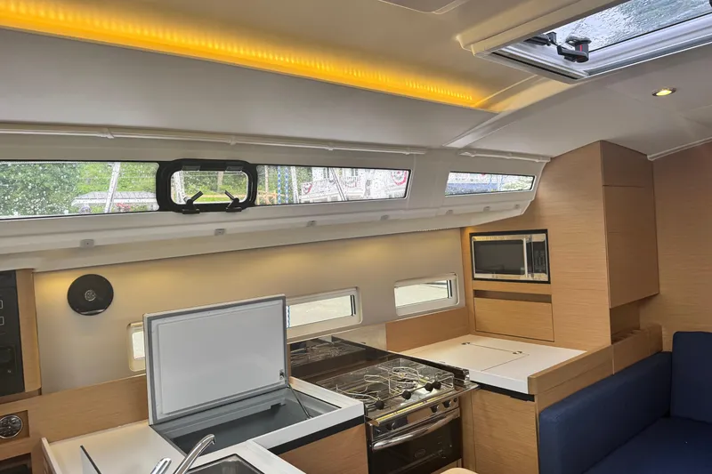 Slide: The Image of Interior of 2020 Jeanneau Sun Odyssey 410 yacht, featuring modern kitchen and seating area. - 20