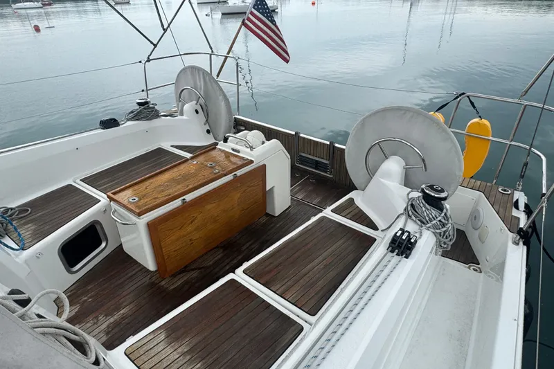 Slide: The Image of 2020 Jeanneau Sun Odyssey 410 sailboat cockpit with wooden table and dual steering wheels. - 7