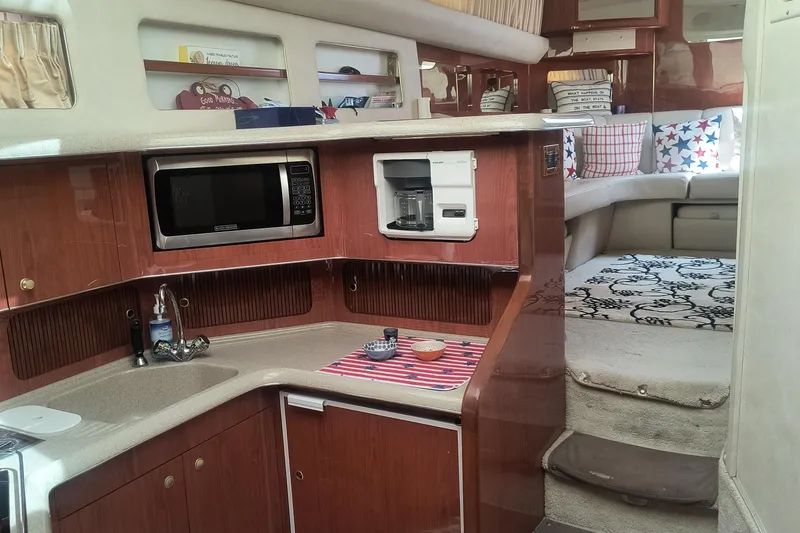 Slide: The Image of 1997 Sea Ray 420 Aft Cabin interior with kitchen and cozy seating area. - 11