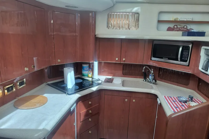 Slide: The Image of 1997 Sea Ray 420 Aft Cabin yacht kitchen with wooden cabinets, stove, and microwave. - 12
