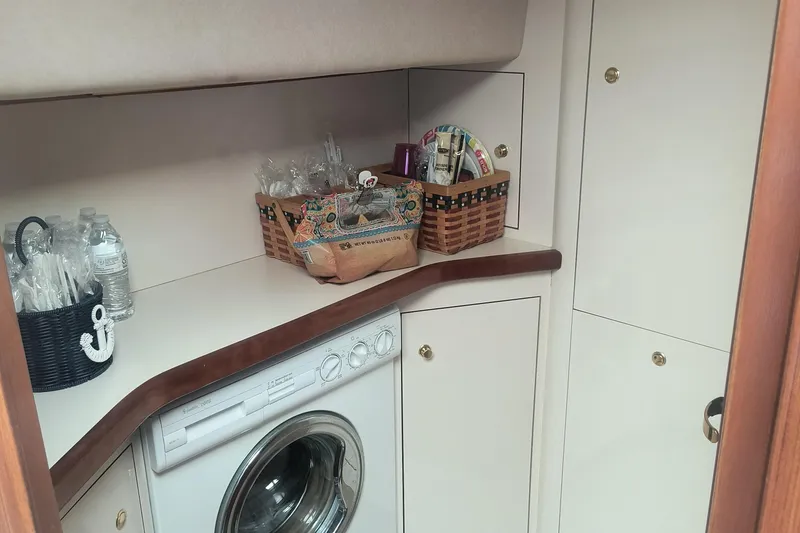 Slide: The Image of Laundry area in 1997 Sea Ray 420 Aft Cabin with washer and storage baskets. - 13