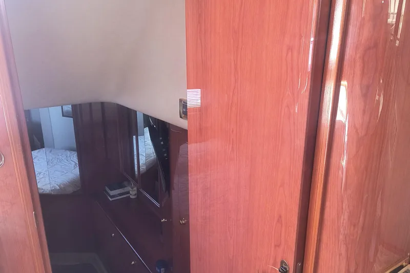 Slide: The Image of Interior of 1997 Sea Ray 420 Aft Cabin with wooden cabinetry and cozy sleeping area. - 14