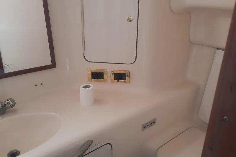 Slide: The Image of Bathroom interior of 1997 Sea Ray 420 Aft Cabin yacht, featuring sink and storage. - 17