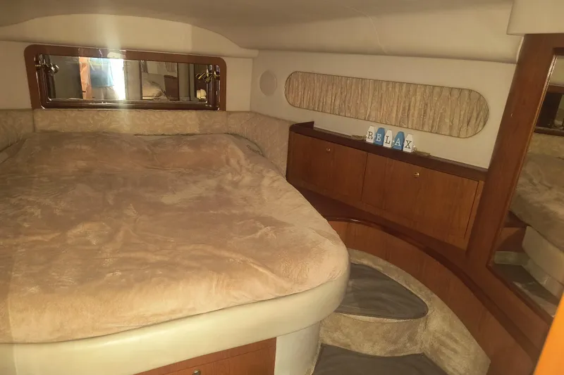 Slide: The Image of Luxurious 1997 Sea Ray 420 Aft Cabin bedroom with cozy bedding and elegant wood cabinetry. - 20