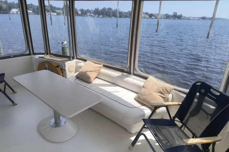 Slide: The Image of 1997 Sea Ray 420 Aft Cabin interior with seating, table, and water view. - 3