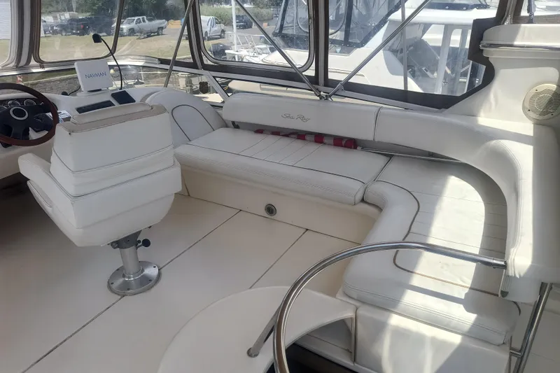Slide: The Image of 1997 Sea Ray 420 Aft Cabin interior with white seating and helm station. - 5