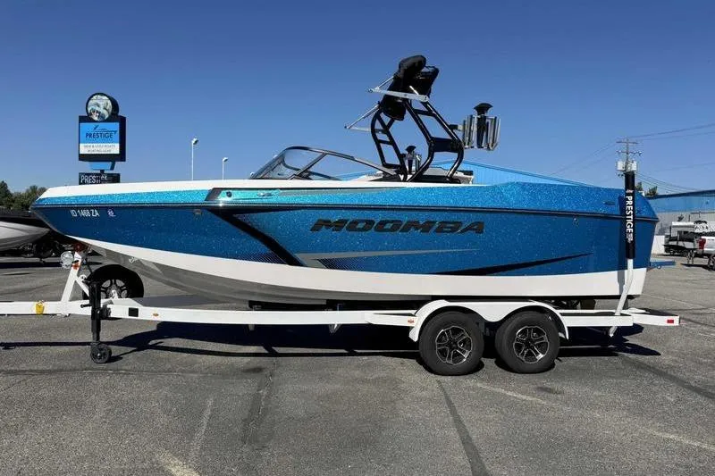 The Image of 2021 Moomba Max boat in blue on a trailer at a dealership. - 1