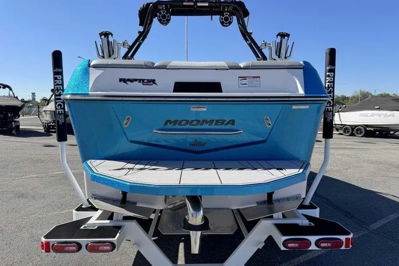 Slide: The Image of 2021 Moomba Max boat rear view, blue exterior, parked on trailer. - 3