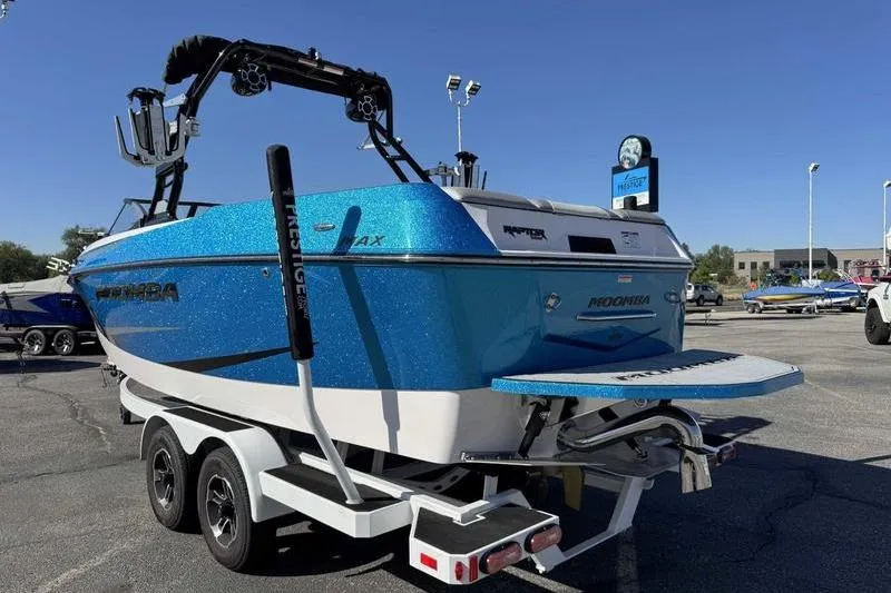 Slide: The Image of 2021 Moomba Max boat in vibrant blue on a trailer, parked outdoors. - 6