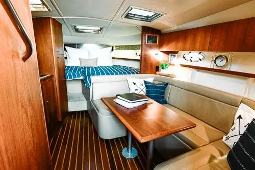 Slide: The Image of 2001 Tiara Yachts 3100 Open cabin interior with wood finish and cozy seating area. - 10