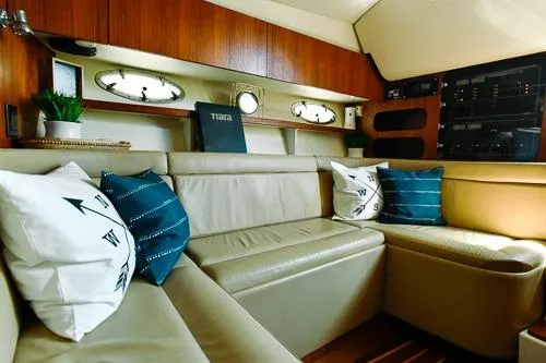 Slide: The Image of 2001 Tiara Yachts 3100 Open interior with beige seating and nautical-themed pillows. - 14