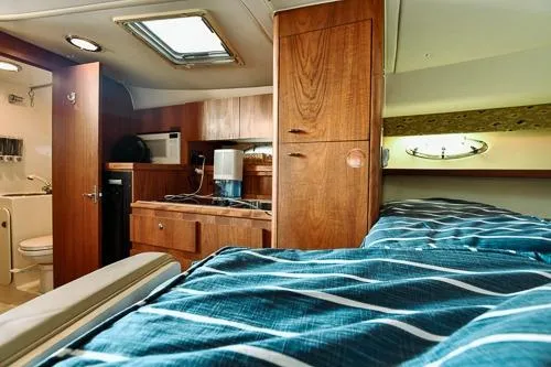 Slide: The Image of Interior of 2001 Tiara Yachts 3100 Open, featuring cozy cabin and kitchenette. - 16