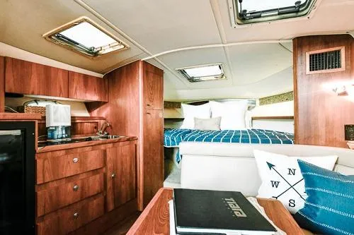 Slide: The Image of 2001 Tiara Yachts 3100 Open interior with wood cabinetry and cozy sleeping area. - 17