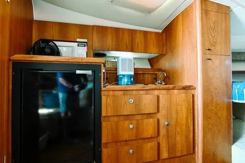 Slide: The Image of 2001 Tiara Yachts 3100 Open interior with wooden cabinetry and compact kitchen area. - 18