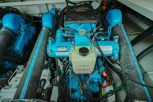 Slide: The Image of Engine compartment of 2001 Tiara Yachts 3100 Open, featuring blue marine engine components. - 21