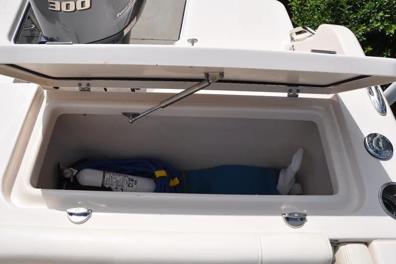 Slide: The Image of Open storage compartment on 2021 Grady-White Fisherman 236 boat, containing safety equipment. - 12