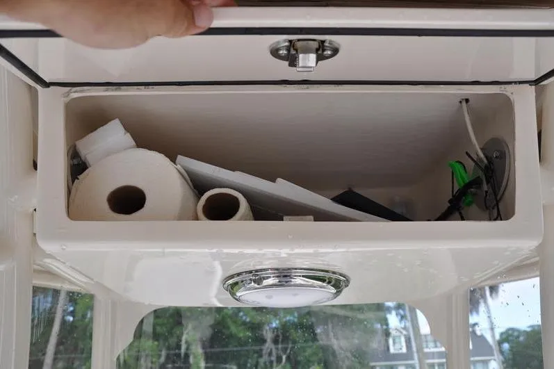 Slide: The Image of Storage compartment on a 2021 Grady-White Fisherman 236 boat, containing paper towels and miscellaneous items. - 24