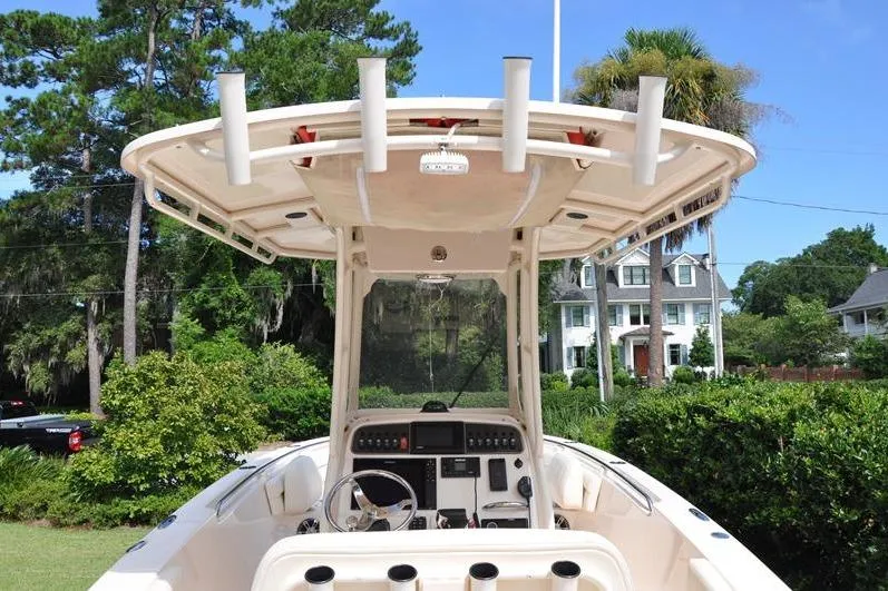 Slide: The Image of 2021 Grady-White Fisherman 236 boat with console and rod holders, surrounded by lush greenery. - 8