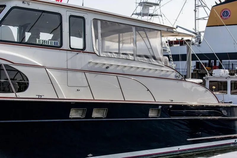 Slide: The Image of 2008 Huckins Linwood yacht docked at a marina, showcasing sleek design and windows. - 10