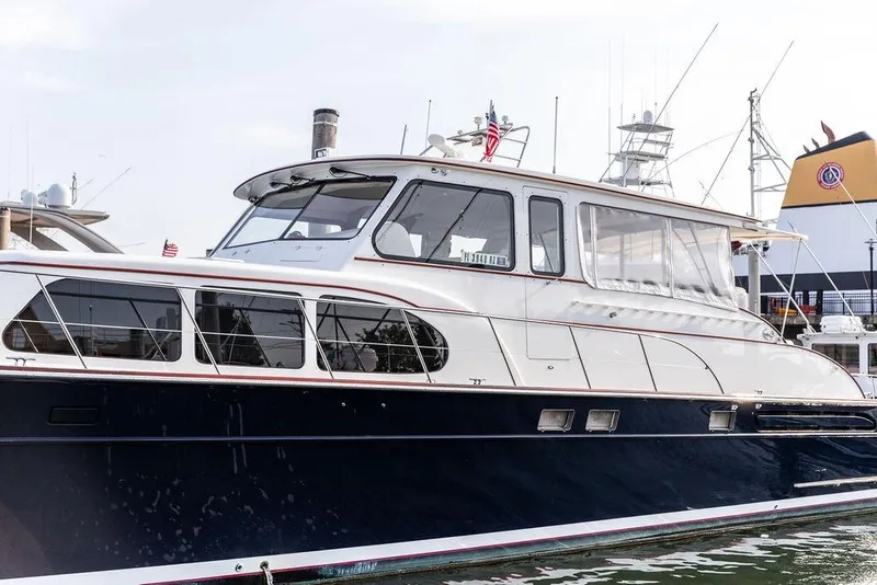 Slide: The Image of 2008 Huckins Linwood yacht docked, featuring sleek design and elegant windows. - 11