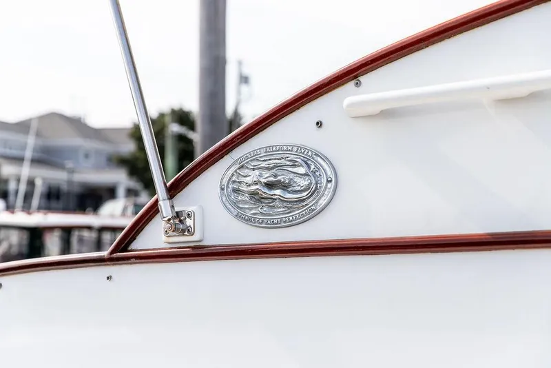 Slide: The Image of 2008 Huckins Linwood boat emblem with polished metal detailing and wooden trim. - 12