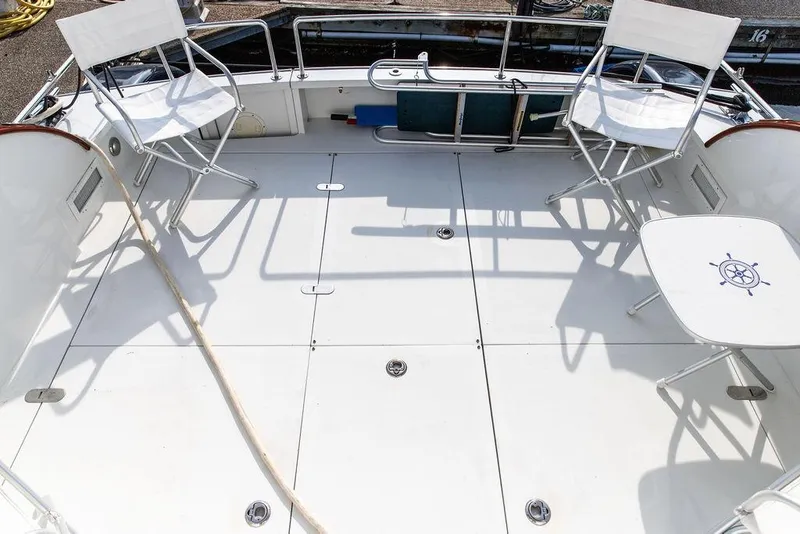 Slide: The Image of Spacious deck of 2008 Huckins Linwood yacht with white chairs and table. - 18