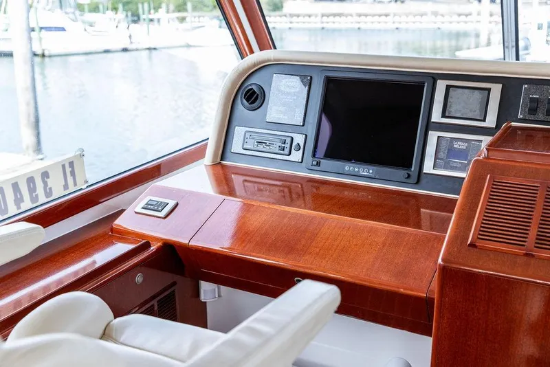 Slide: The Image of 2008 Huckins Linwood yacht helm with polished wood finish and modern navigation equipment. - 20