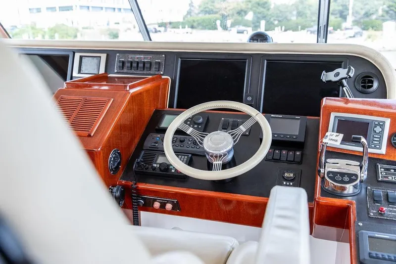Slide: The Image of 2008 Huckins Linwood yacht helm with modern navigation controls and wooden dashboard. - 21