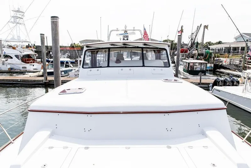 Slide: The Image of 2008 Huckins Linwood yacht docked at a marina, showcasing sleek design and craftsmanship. - 31