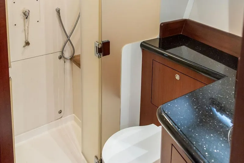 Slide: The Image of 2008 Huckins Linwood yacht bathroom with shower, sleek countertop, and wooden cabinetry. - 32