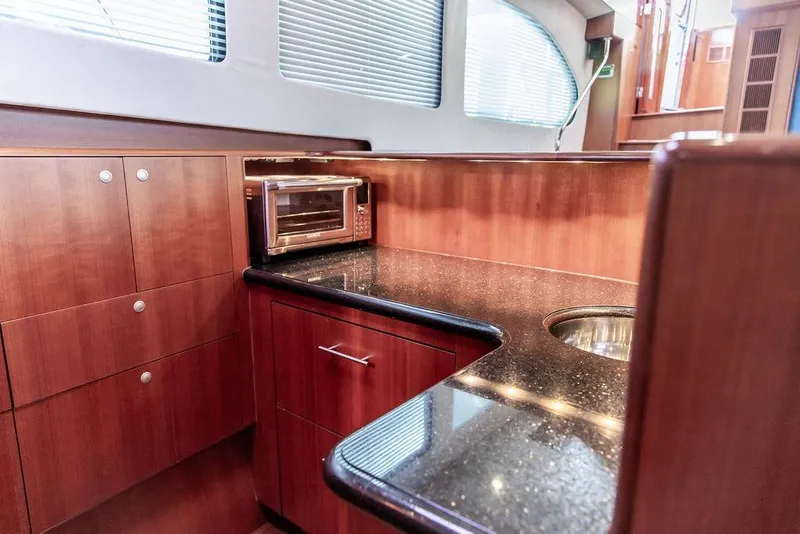 Slide: The Image of Luxurious 2008 Huckins Linwood yacht interior with sleek wood cabinetry and modern appliances. - 4