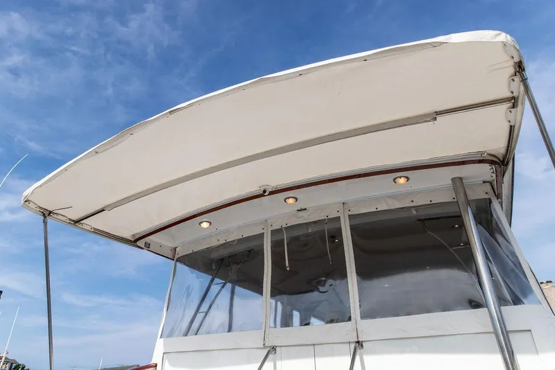 Slide: The Image of 2008 Huckins Linwood boat canopy with clear panels under a blue sky. - 7