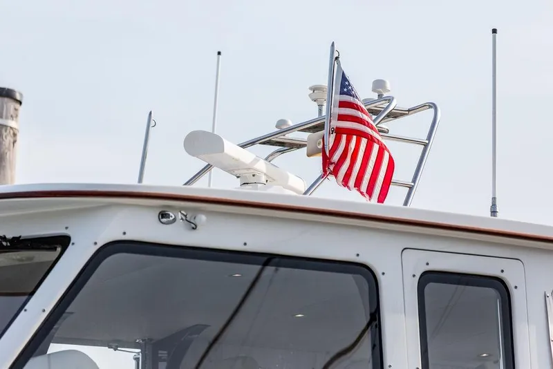 Slide: The Image of 2008 Huckins Linwood yacht with American flag on deck, showcasing sleek design. - 9