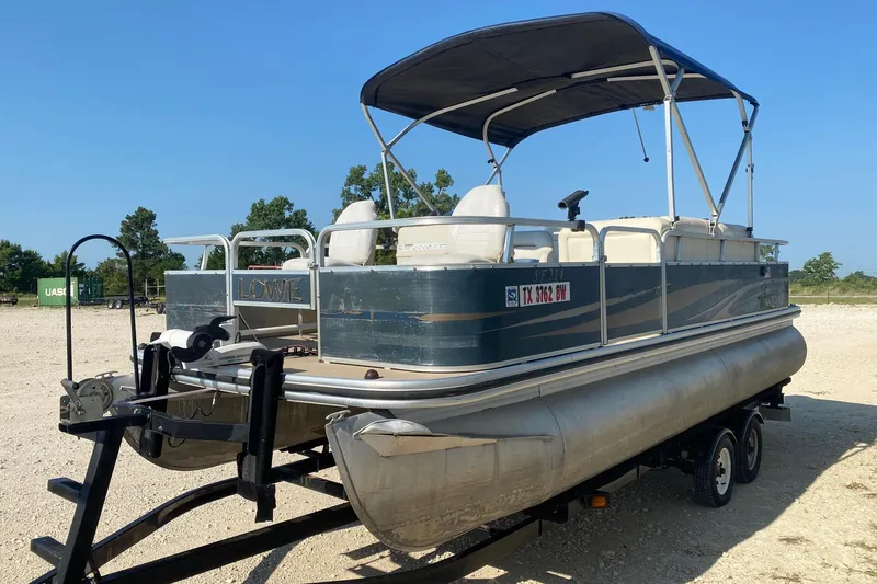 Slide: The Image of 2014 Lowe SF214 Sport Fish pontoon boat on trailer, parked outdoors. - 2