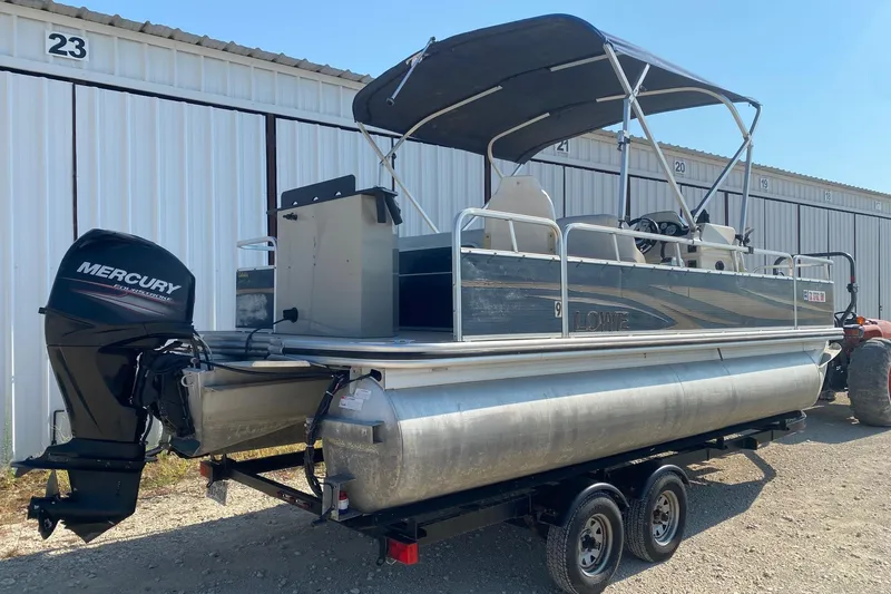 Slide: The Image of 2014 Lowe SF214 Sport Fish pontoon boat with Mercury outboard motor, parked on a trailer. - 5