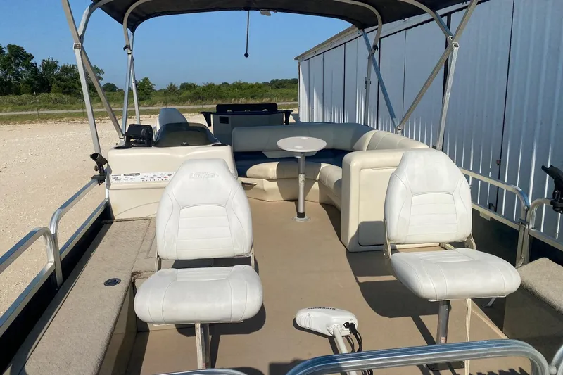 Slide: The Image of 2014 Lowe SF214 Sport Fish boat with white seating and canopy, parked outdoors. - 6