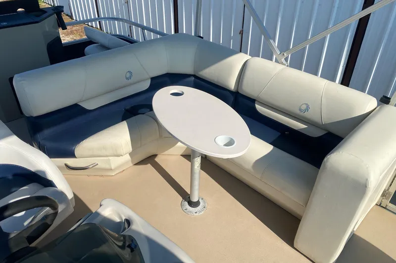 Slide: The Image of 2014 Lowe SF214 Sport Fish boat interior with white and blue seating and a small table. - 7